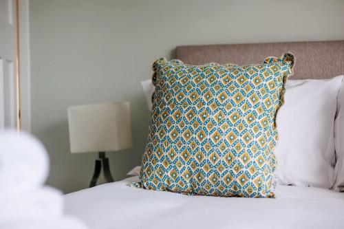 a pillow sitting on top of a bed at Primrose - Refurbished Family Home, With Rear Garden in Poole