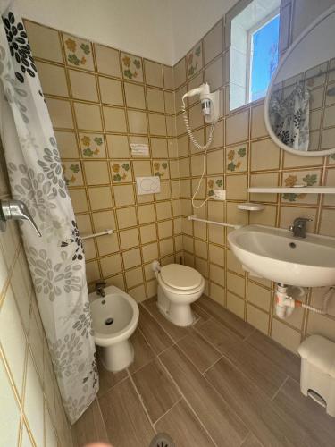 a small bathroom with a toilet and a sink at Villa Antonio in Forio d'Ischia