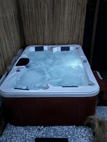 a jacuzzi tub sitting on top of rocks at Maison neuve & lumineuse avec jacuzzi privatif in Ploemeur