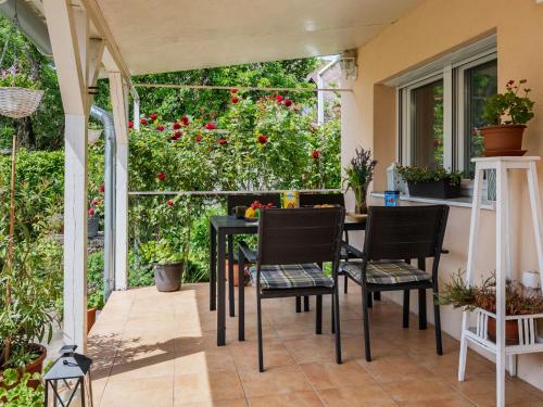 a patio with a table and chairs and flowers at Holiday Home Nádor - FOD125 by Interhome in Fehérbézseny