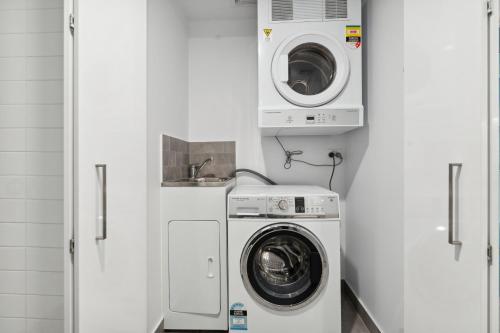 a laundry room with a washer and a washing machine at Boho retreat near The Gabba with stunning views in Brisbane