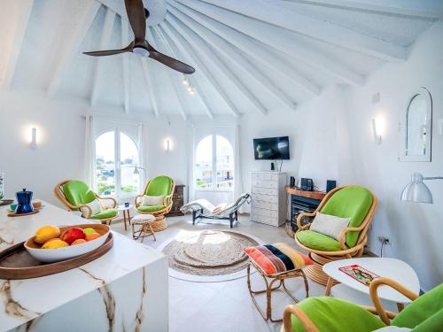 a living room with green chairs and a ceiling at Holiday Home Villa Sol by Interhome in Calpe