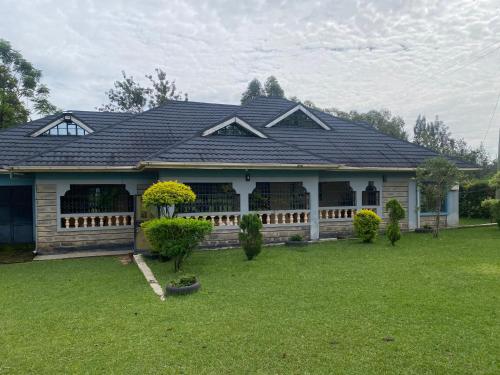 a house with a black roof on a yard at Maramba blissful home in Kakamega