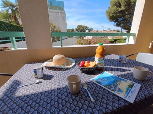 une table avec un chiffon de table bleu et une corbeille de fruits dans l'établissement Apartment Résidence Villa Toscane by Interhome, à Saint-Raphaël