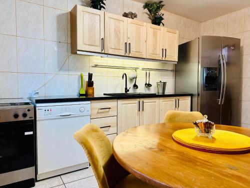 a kitchen with a wooden table and a kitchen with a refrigerator at Iepurasul Sinaia in Sinaia