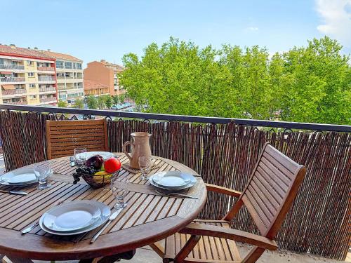 une table et des chaises en bois sur un balcon dans l'établissement Apartment Le Rabelais-1 by Interhome, à Saint-Aygulf