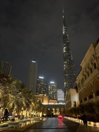 a view of a city at night with a tall building at Cozy 1BR Apart Downtown Burj Khalifa and Dubai Mall in Dubai