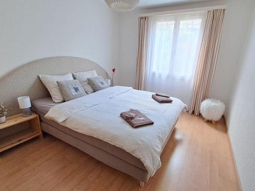 a bedroom with a large bed with a robe on it at Apartment Bergluft by Interhome in Zweisimmen