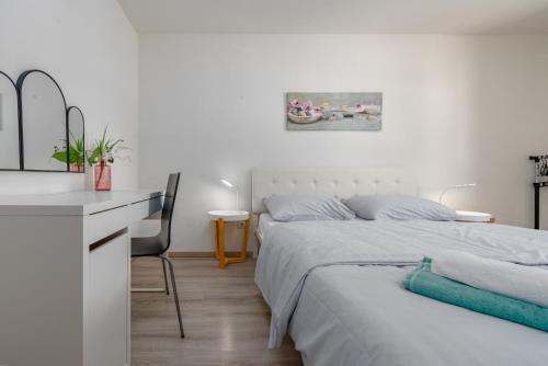 a white bedroom with two beds and a desk at Holiday Home Burgija with pool in Benkovac