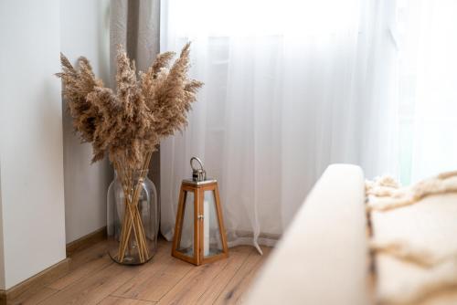 two vases with flowers on a floor next to a window at Geri Harmony Home in Zalaegerszeg