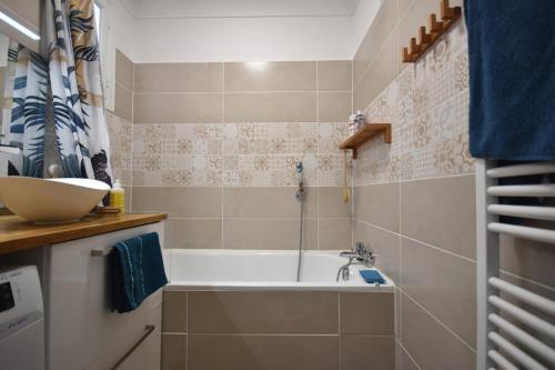 une salle de bain avec une baignoire et un lavabo dans l'établissement T2 proche de la mer, à Marseille