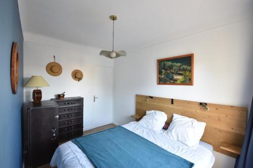 - une chambre avec un lit doté d'une couverture bleue et d'une commode dans l'établissement T2 proche de la mer, à Marseille