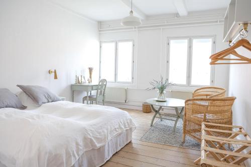 a white bedroom with a bed and a table at Lundsgaard Gods Badehotel in Kerteminde