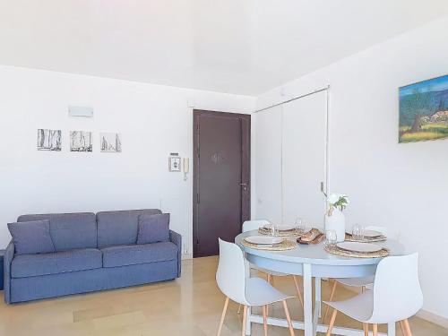 un salon avec une table et un canapé bleu dans l'établissement Apartment Le Bonaparte-2 by Interhome, à Roquebrune-Cap-Martin