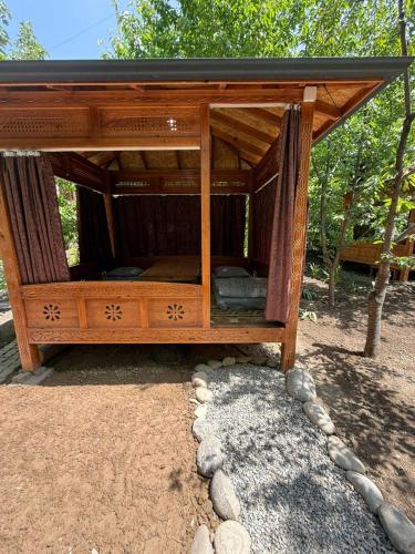 a wooden bed with a canopy in a park at Lovely home in Osh