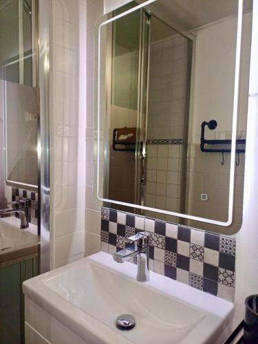 une salle de bain avec un lavabo et un miroir dans l'établissement Escapades Bohème - 3 pers - Histoire de Clés, au Cap d'Agde