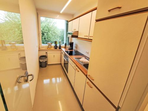 a small kitchen with a refrigerator and a window at Apartment Seezugang & Ski Ossiacher See by Interhome in Bodensdorf
