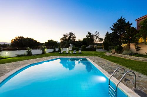 a swimming pool in the yard of a house at Villa Aurora Crete in Koxaré