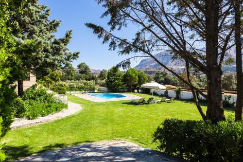 a garden with a swimming pool and mountains in the background at Villa Aurora Crete in Koxaré