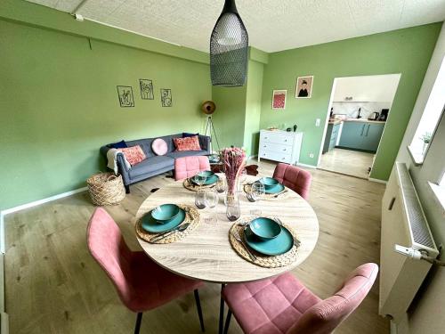 a dining room with a table and pink chairs at Familien Apartment inkl Spielecke nähe Pullman City Westernstadt in Hasselfelde