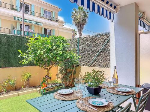 - une table avec des assiettes et des verres à vin sur la terrasse dans l'établissement Apartment New Beach-2 by Interhome, à Roquebrune-Cap-Martin