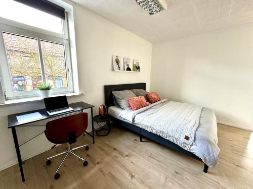 a bedroom with a bed and a desk with a laptop at Familien Apartment inkl Spielecke nähe Pullman City Westernstadt in Hasselfelde