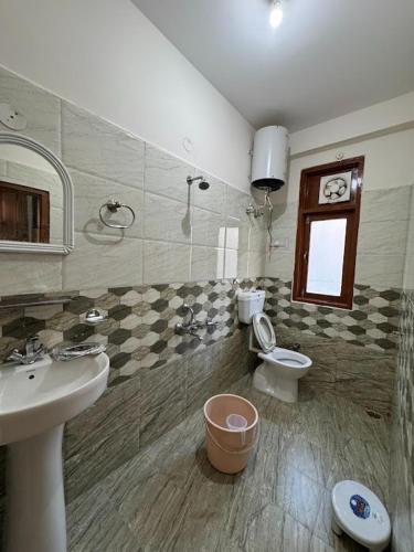 a bathroom with a sink and a toilet at KK Homestay Bhuntar - By Soma Stays in Shamshi