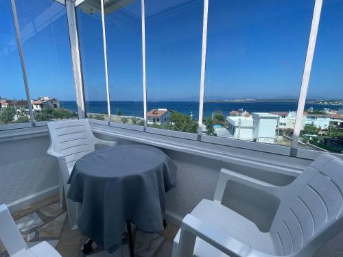 a table and chairs in a room with windows at Teras in Seferihisar