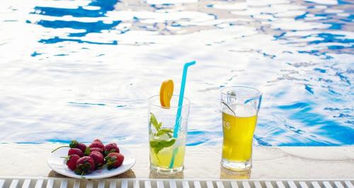 a drink and a plate of fruit next to a pool at Teras in Seferihisar