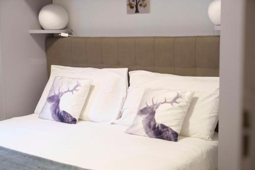 - un lit avec 2 oreillers en cerf dans l'établissement DOLOMIA APARTMENTS PINZOLO vicino alle funivie, à Pinzolo