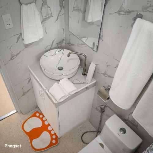 a bathroom with a toilet and a sink and a mirror at the Landing Villas rental in Panglao