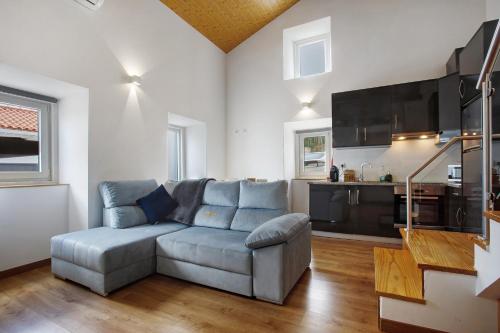 a living room with a couch and a kitchen at Moradia Dos Castelos Azul in Ourém