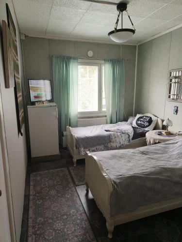 a room with three beds and a window and a room with two beds at Kiinteistö Hetekka in Kouvola