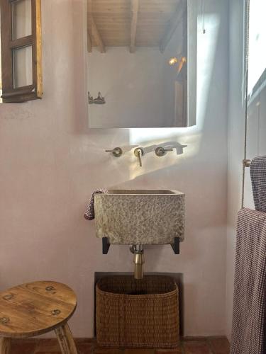 a bathroom with a sink and a mirror and a stool at Caso no Campo - Stunning Home By The Sea in Colares