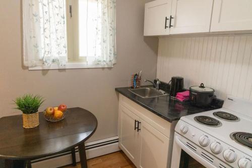 a small kitchen with a table and a sink at Tranquil Retreats on Robinson in Moncton