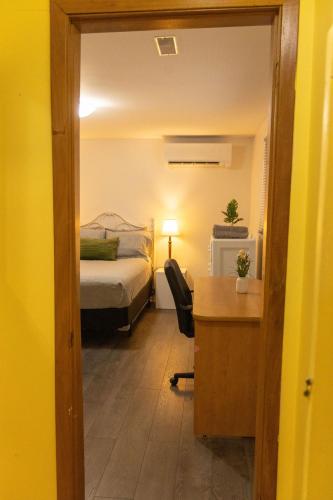 a bedroom with a bed and a desk with a desk at Tranquil Retreats on Robinson in Moncton