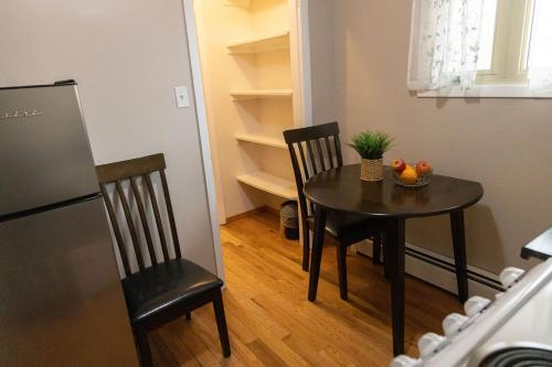 a kitchen with a table and two chairs with a bowl of fruit at Tranquil Retreats on Robinson in Moncton