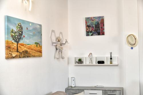 a living room with three pieces of art on the wall at Perla Apartment con vista mare in Olbia