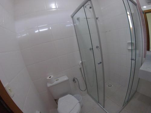 a bathroom with a toilet and a glass shower at Hotel Hola in Florianópolis