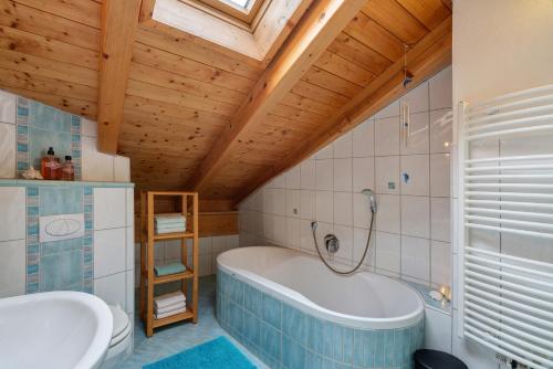 a bathroom with a tub and a toilet and a sink at Fewo Oberschönauer Bergblick in Schönau am Königssee