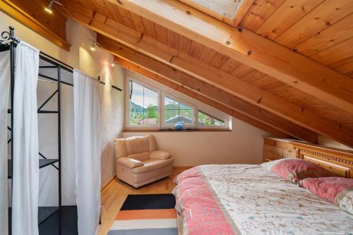 a bedroom with a bed and a chair in a room at Fewo Oberschönauer Bergblick in Schönau am Königssee