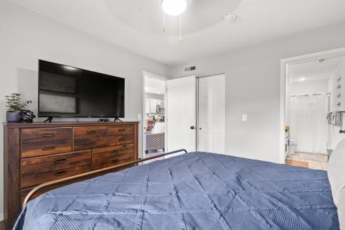 a bedroom with a bed with a tv on a dresser at Family and Pet friendly ground level Condo, 4 mins to Silver Dollar City, Amazing Ozark Mountain Views in Branson