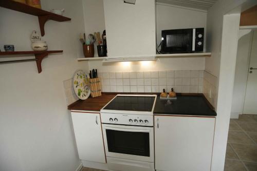 a kitchen with a stove and a microwave at Child-Friendly Holiday 500 Meters From The Beach in Nykøbing Sjælland