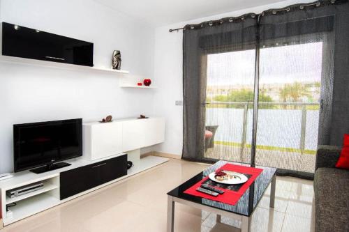 sala de estar con ventana grande y mesa en Apartment Escorpiones, en Torrevieja