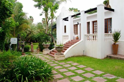 a white house with some plants in the yard at Green Gables Guest House in Upington
