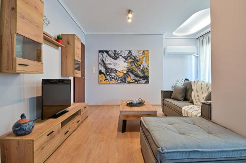 a living room with a couch and a tv at Elegant Sea View Stay - Piraeus Port in Piraeus