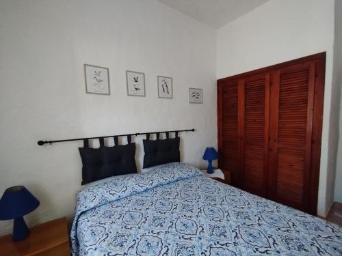 a bedroom with a bed with a blue comforter at Capo Coda Cavallo, vacanze nella casa Il Maestrale in Capo Coda Cavallo