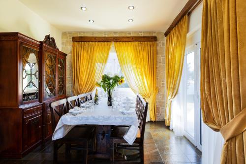 a dining room with a table with a vase of flowers on it at Villa Aurora Crete in Koxaré