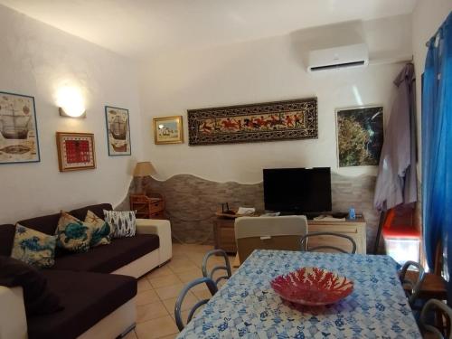 a living room with a couch and a table at Capo Coda Cavallo, vacanze nella casa Il Maestrale in Capo Coda Cavallo