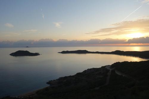 a view of a large body of water at sunset at Capo Coda Cavallo, vacanze nella casa Il Maestrale in Capo Coda Cavallo
